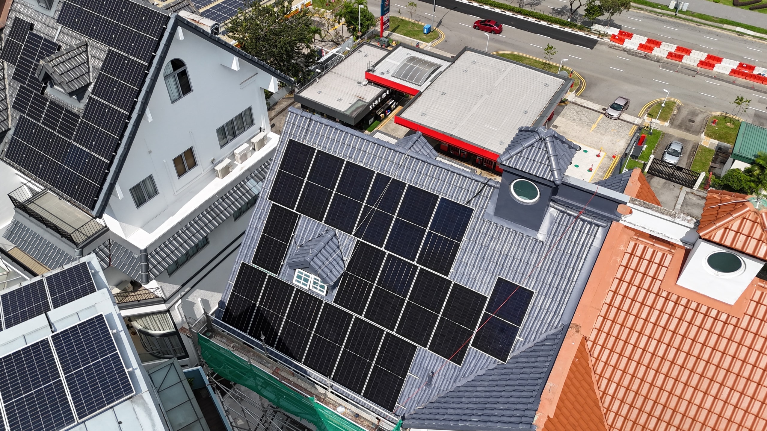 Drone view of the detached house showing the full panel array and the surrounding estate